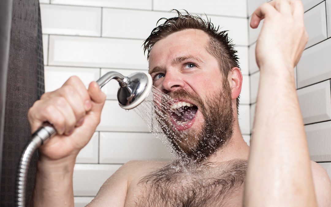 Ein Mann benutzt einen Duschkopf als Mikrofon